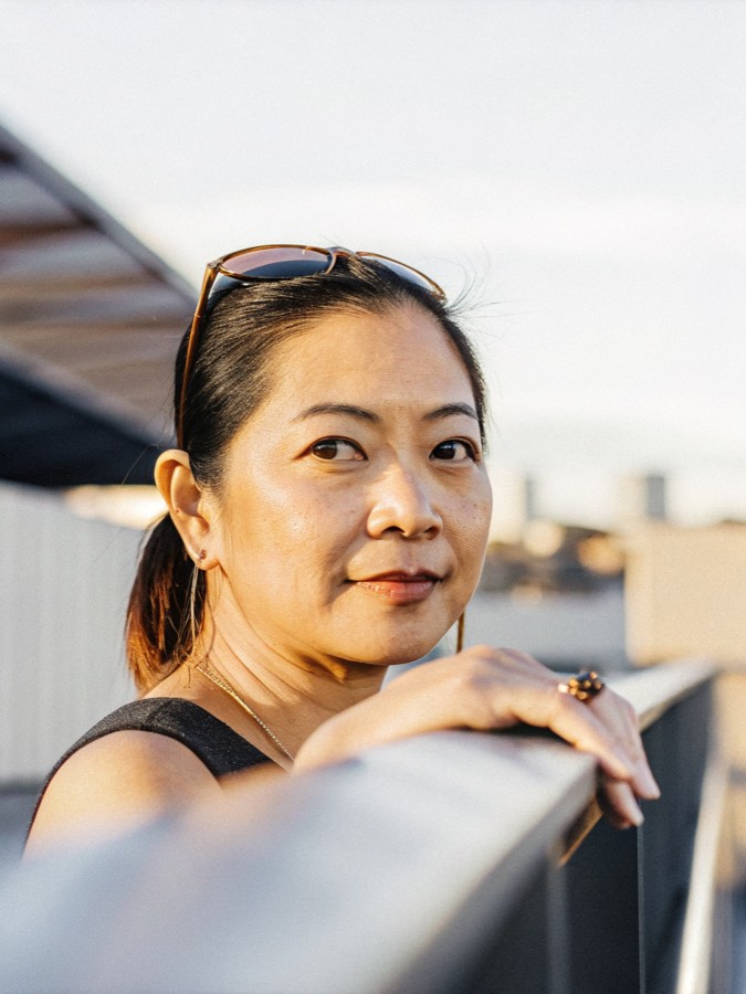 a Vietnamese American woman in her early forties on a balcony at golden hour